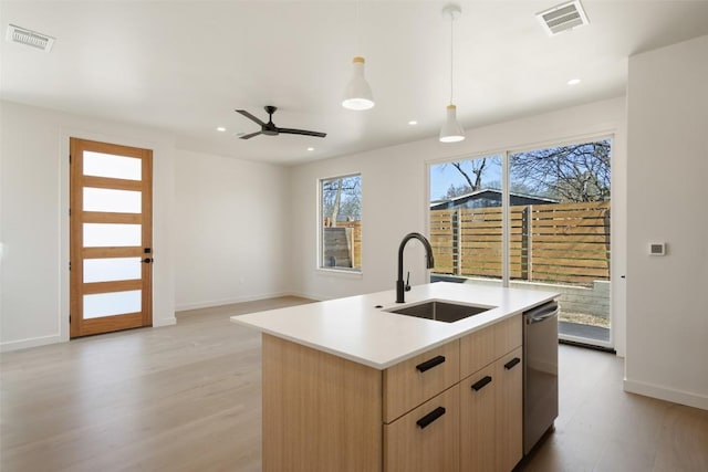 2912 Pecan Springs Rd, Austin, TX 78723 - kitchen featuring dishwasher, light wood-type flooring, light brown cabinetry, recessed lighting, and light countertops