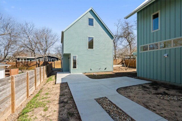 2912 Pecan Springs Rd, Austin, TX 78723 - rear view of property featuring board and batten siding, a patio area, and a fenced backyard