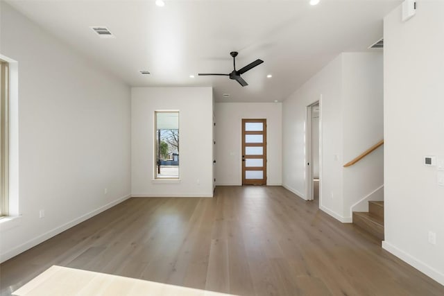 entryway featuring visible vents, light wood-style floors, ceiling fan, baseboards, and stairs