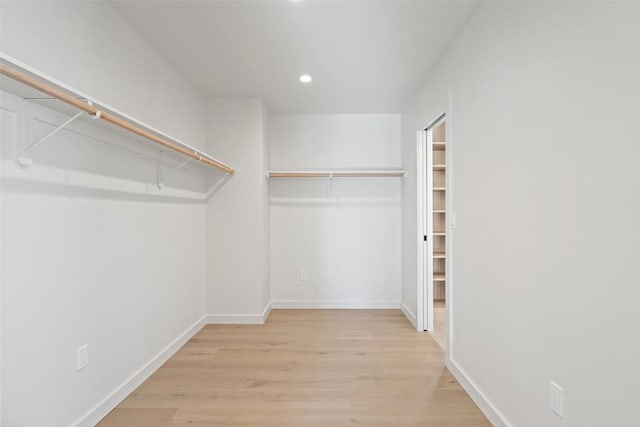 walk in closet with wood finished floors