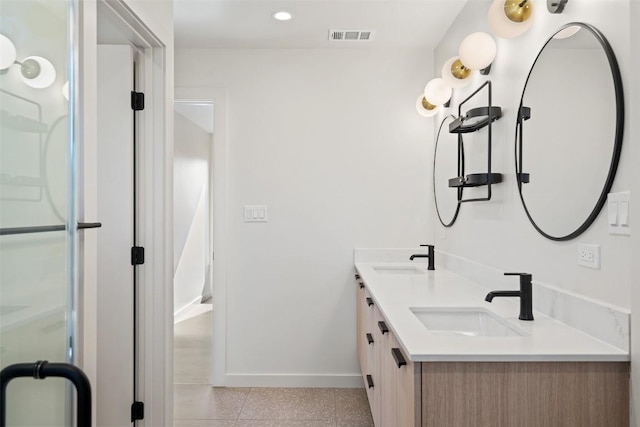 full bathroom with double vanity, a sink, visible vents, and baseboards