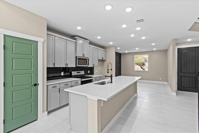 17503 Panorama Dr, Dripping Springs, TX 78620 - kitchen with stainless steel microwave, electric range oven, a sink, baseboards, and gray cabinetry