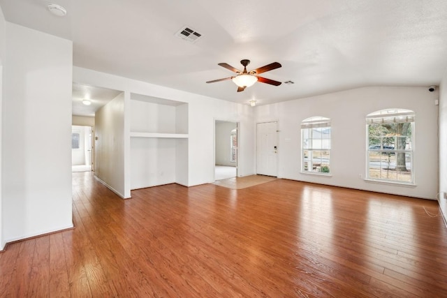 unfurnished living room with visible vents, baseboards, built in features, hardwood / wood-style flooring, and a ceiling fan