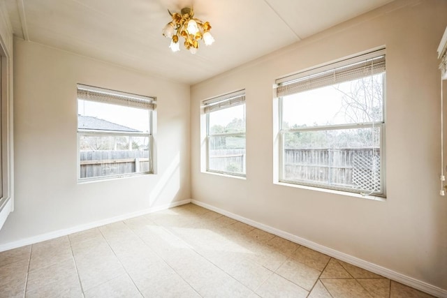 spare room with tile patterned flooring and baseboards