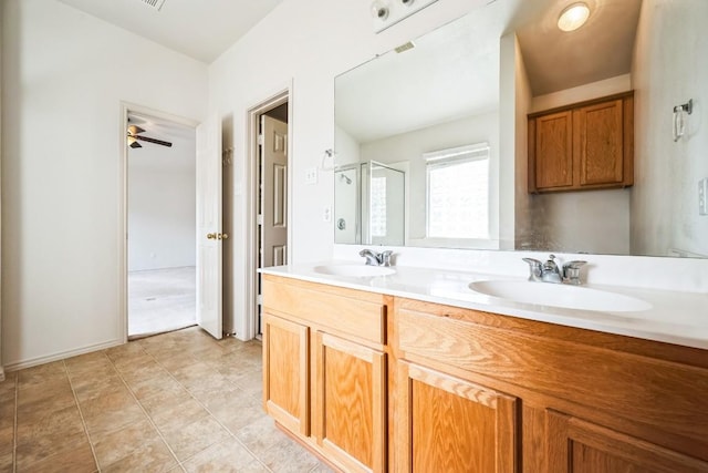 full bath featuring double vanity, tile patterned floors, a stall shower, and a sink