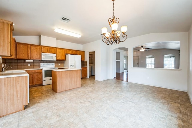 kitchen featuring white appliances, lofted ceiling, a sink, decorative backsplash, and light countertops