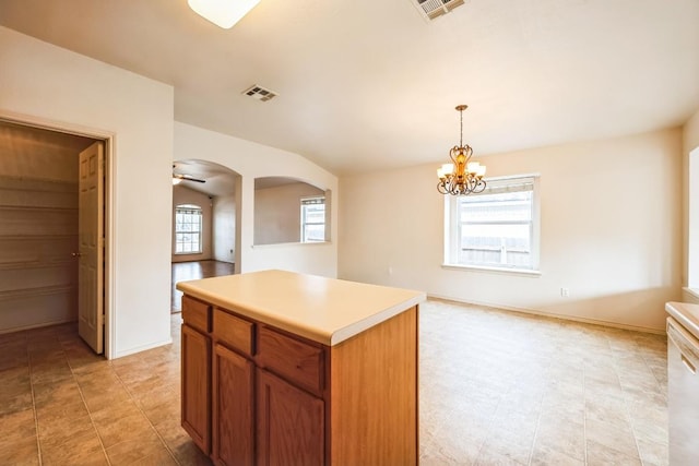 kitchen featuring light countertops, arched walkways, visible vents, and pendant lighting