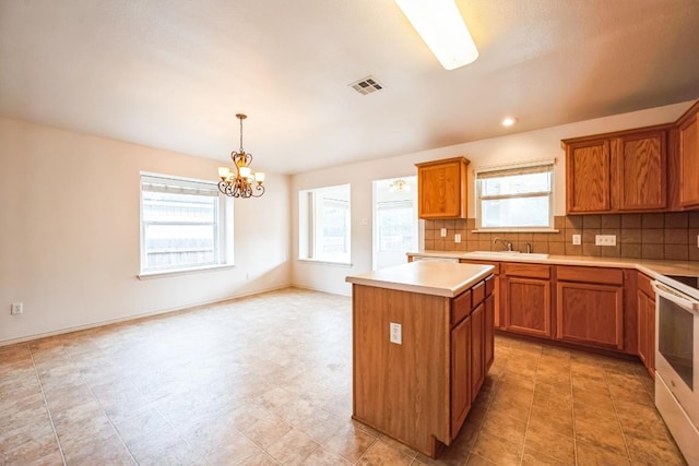 kitchen with decorative backsplash, brown cabinets, a kitchen island, and plenty of natural light