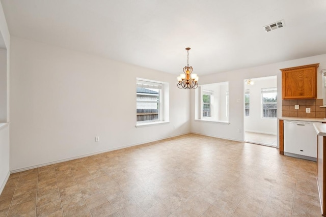 unfurnished dining area with a notable chandelier, baseboards, and visible vents