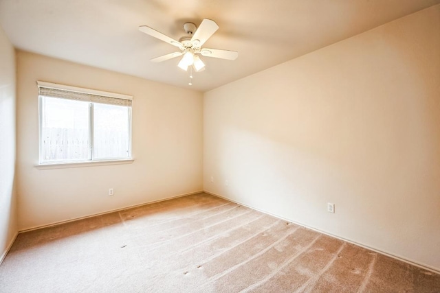 carpeted empty room with a ceiling fan