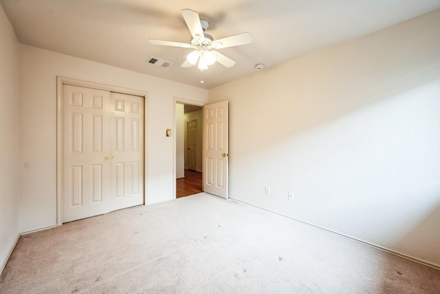 unfurnished bedroom with ceiling fan, visible vents, a closet, and carpet floors