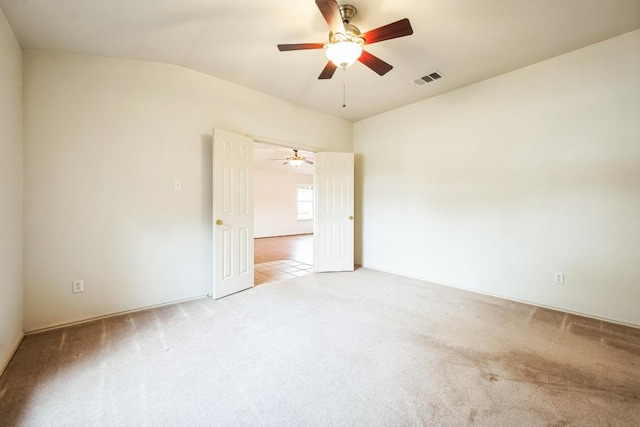 unfurnished room with light carpet, visible vents, a ceiling fan, and lofted ceiling