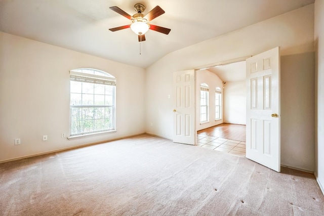 spare room with tile patterned floors, lofted ceiling, ceiling fan, and carpet flooring