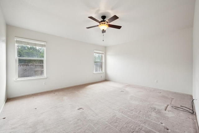 carpeted spare room with ceiling fan