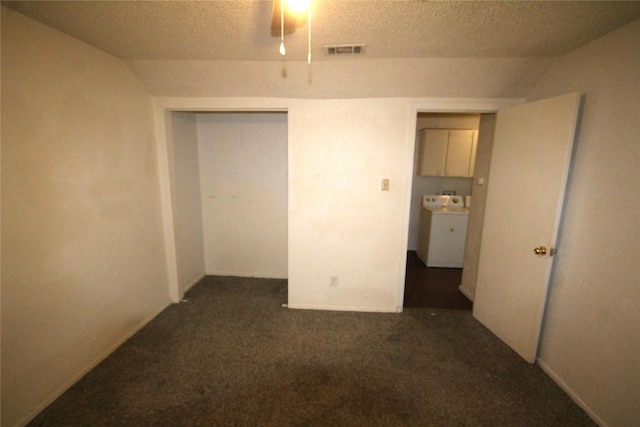 unfurnished bedroom featuring a textured ceiling, visible vents, a closet, washer / clothes dryer, and dark carpet