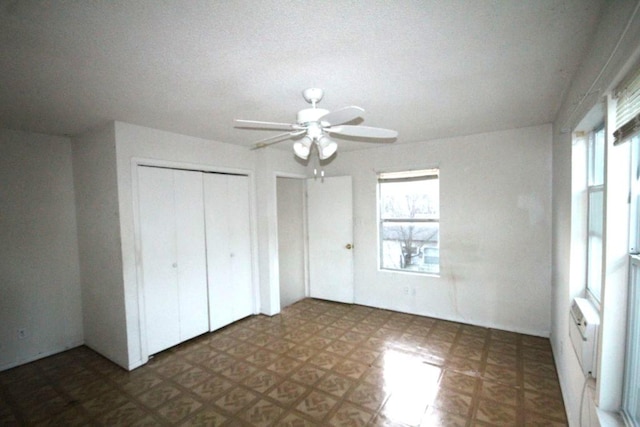 unfurnished bedroom with ceiling fan, multiple windows, two closets, and tile patterned floors