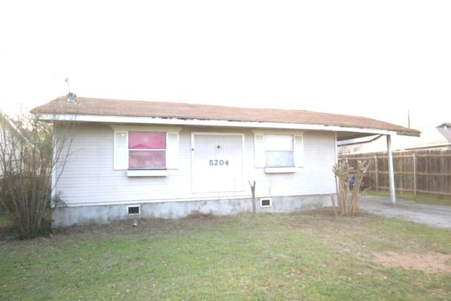 view of home's exterior with a carport, a yard, fence, and driveway