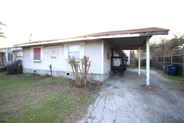 manufactured / mobile home featuring driveway, a carport, and fence