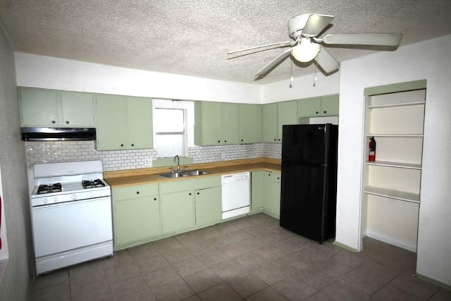 kitchen featuring white appliances, tasteful backsplash, under cabinet range hood, and a sink