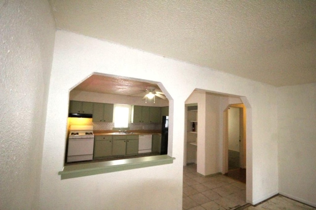 kitchen featuring arched walkways, under cabinet range hood, white appliances, a sink, and green cabinetry