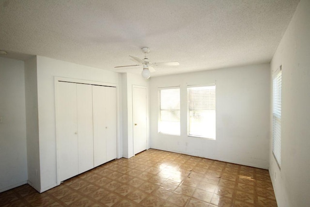 unfurnished bedroom featuring ceiling fan, a textured ceiling, and tile patterned floors