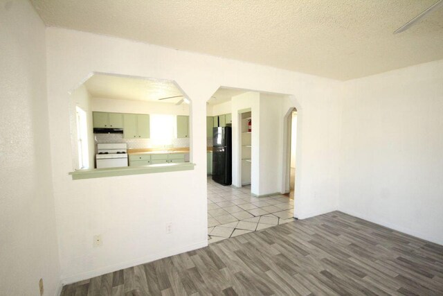 5204 Guadalupe St, Austin, TX 78751 - unfurnished room featuring arched walkways, wood finished floors, a ceiling fan, and a textured ceiling
