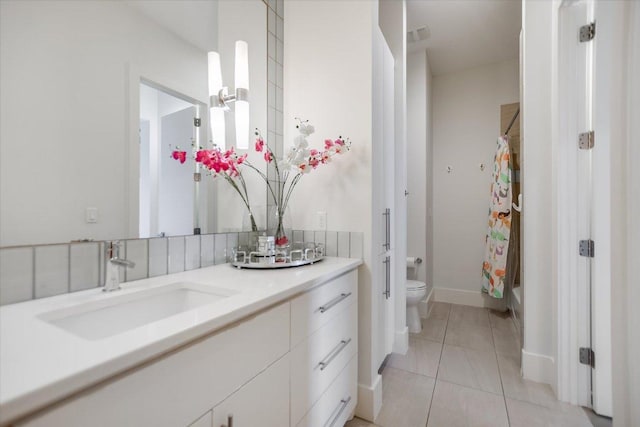 full bathroom featuring tile patterned floors, toilet, vanity, and tasteful backsplash