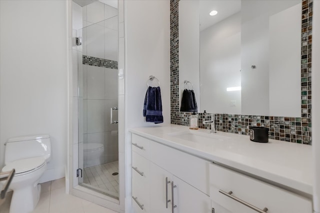 bathroom with tile patterned flooring, backsplash, a shower stall, toilet, and vanity