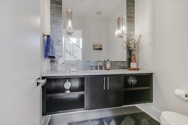 bathroom with toilet, vanity, and baseboards