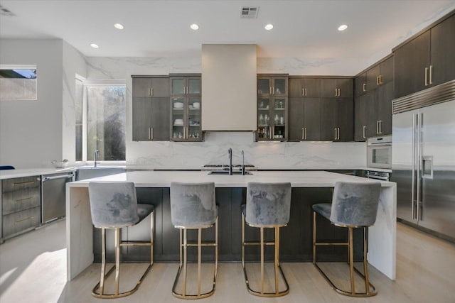 kitchen with visible vents, backsplash, stainless steel appliances, light countertops, and glass insert cabinets