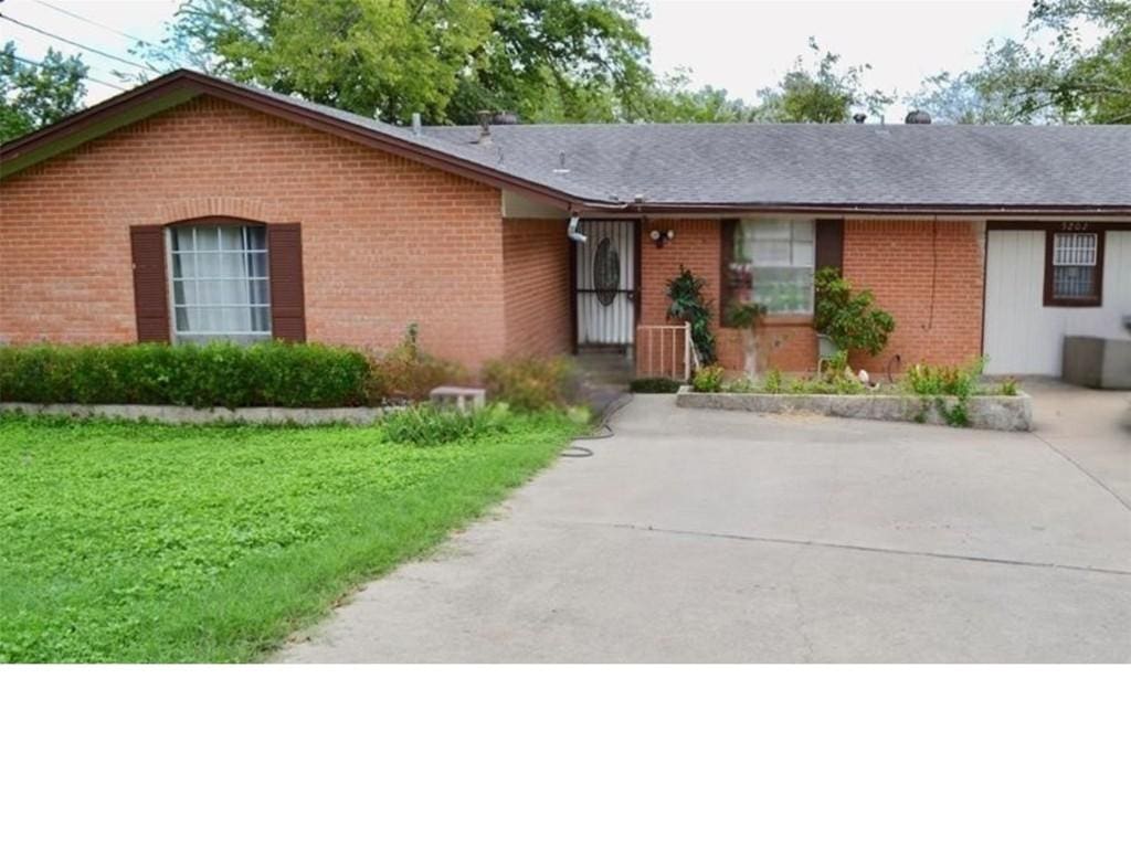 single story home featuring brick siding and a front lawn