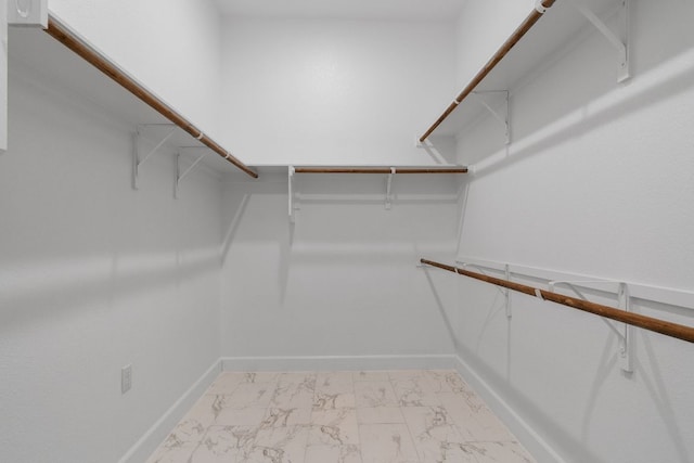 walk in closet with marble finish floor