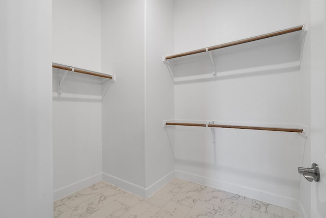 spacious closet featuring marble finish floor