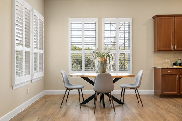 dining space with baseboards and light wood finished floors