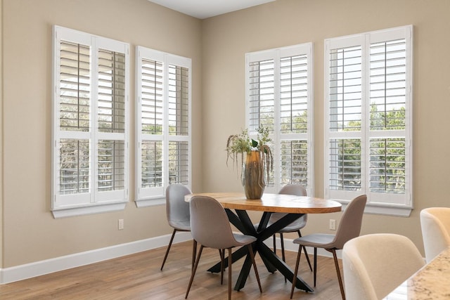 dining area featuring a healthy amount of sunlight, baseboards, and wood finished floors