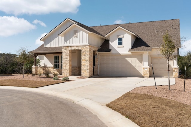 view of front of property featuring a garage, concrete driveway, board and batten siding, and stone siding