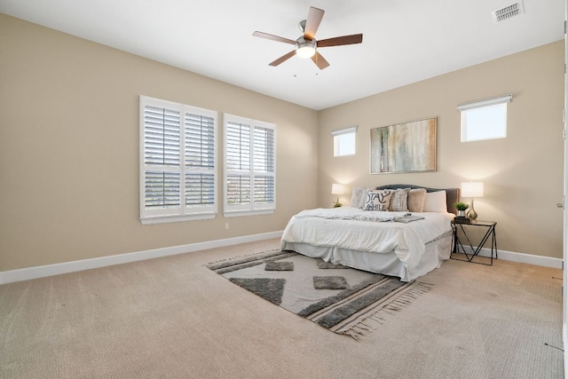 carpeted bedroom with visible vents, ceiling fan, and baseboards