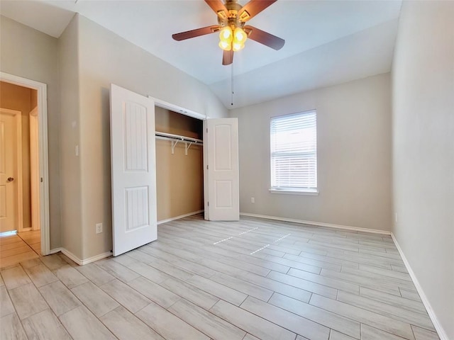 unfurnished bedroom with lofted ceiling, a ceiling fan, baseboards, and a closet