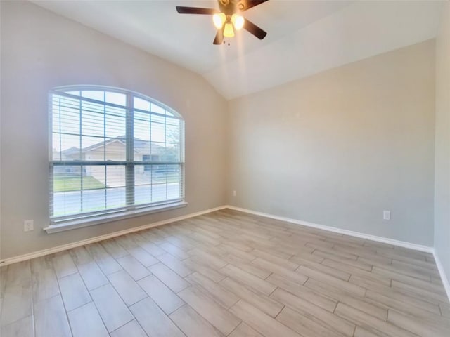 unfurnished room with lofted ceiling, light wood-style floors, baseboards, and a ceiling fan