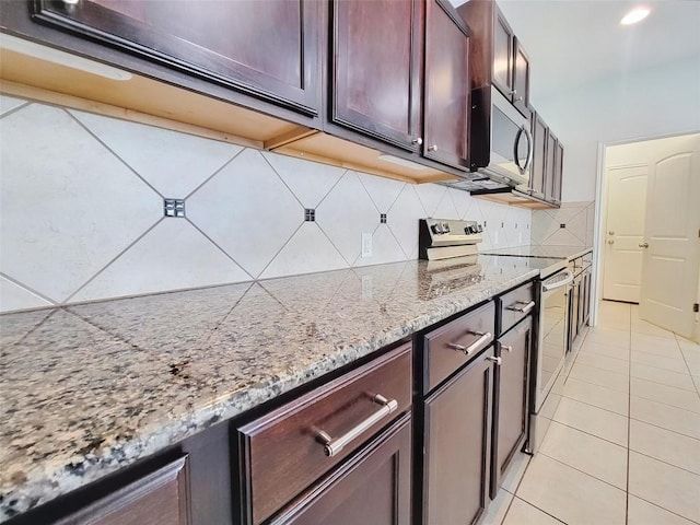 kitchen with light tile patterned floors, tasteful backsplash, appliances with stainless steel finishes, light stone countertops, and recessed lighting