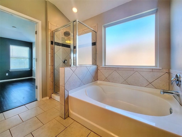 bathroom with a shower stall, baseboards, a bath, and tile patterned floors