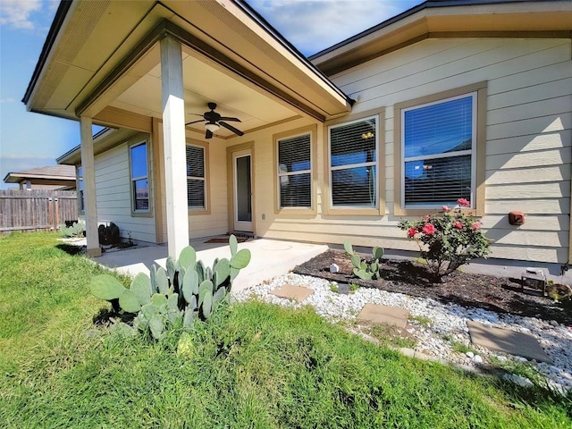 exterior space featuring a lawn, ceiling fan, a patio, and fence