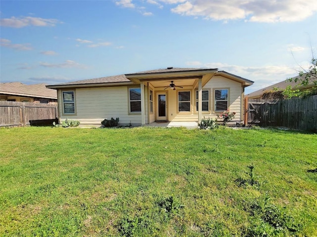 view of front facade featuring a ceiling fan, a front yard, and a fenced backyard