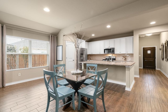 dining room featuring dark wood-type flooring, recessed lighting, and baseboards