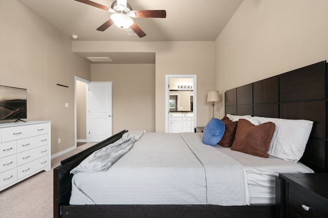 carpeted bedroom with ceiling fan, ensuite bath, and baseboards