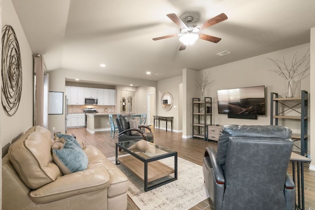 living area with recessed lighting, visible vents, a ceiling fan, light wood-type flooring, and baseboards