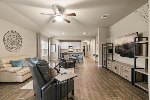 living room featuring baseboards, wood tiled floor, visible vents, and a ceiling fan