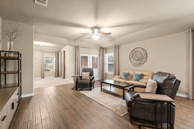 living room with lofted ceiling, wood tiled floor, baseboards, and a ceiling fan