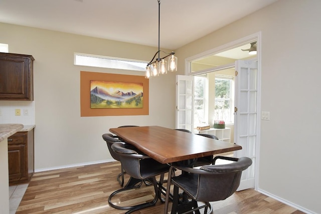 dining area featuring baseboards and light wood finished floors