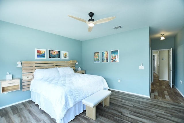 bedroom featuring baseboards, visible vents, ceiling fan, and wood finished floors